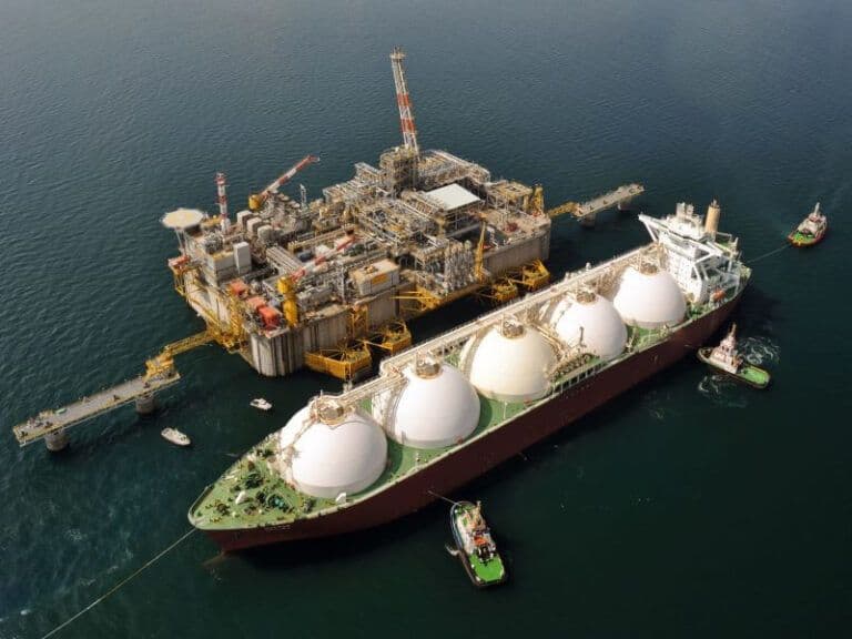An offshore platform with a large vessel surrounded by several smaller vessels next to it